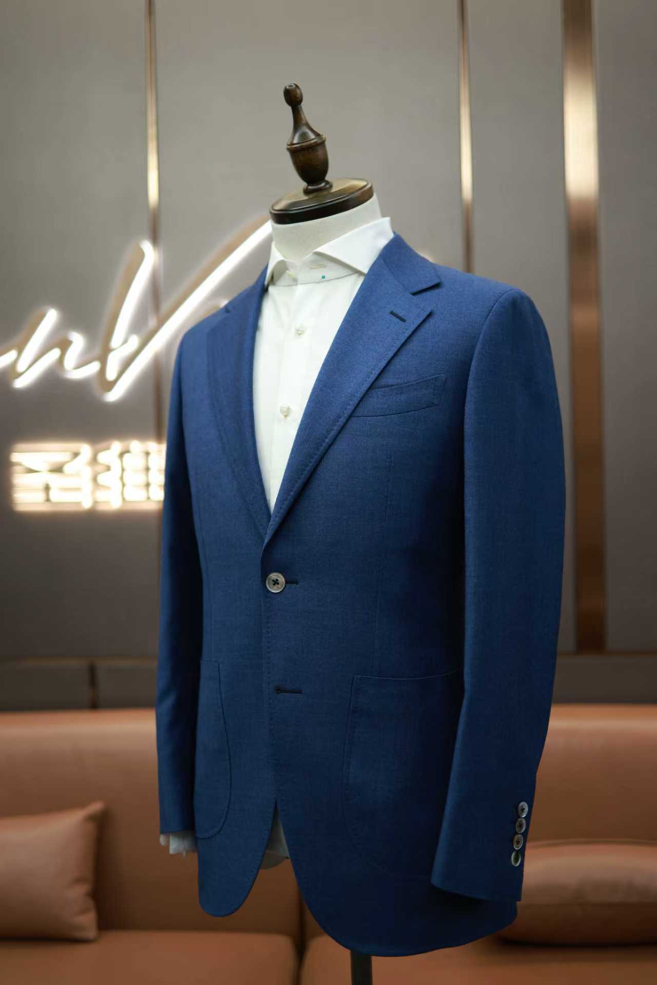 Man in bespoke suit being measured by tailor, professional indoor lighting